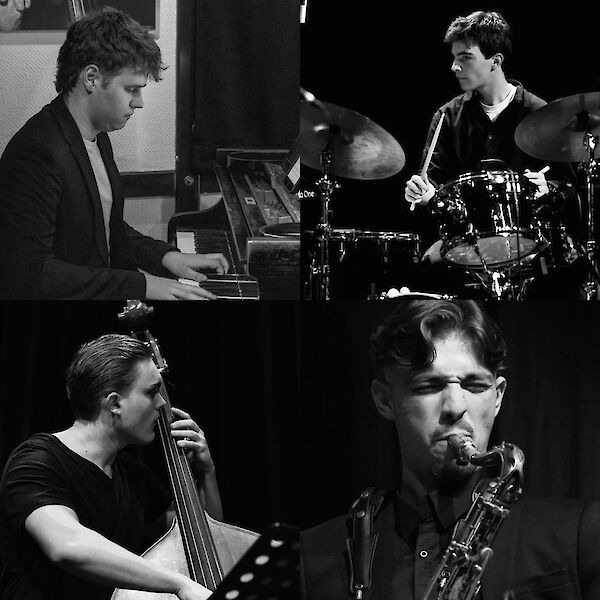 Das schwarz-weiße Bild zeigt eine vierköpfige Jazzband während einer Aufführung mit einem Pianisten oben links, einem Schlagzeuger oben rechts, einem Kontrabassisten unten links und einem Saxophonisten unten rechts. Alle Musiker sind konzentriert beim Spielen ihrer Instrumente zu sehen, was die intensive Atmosphäre einer Live-Jazz-Performance vermittelt.